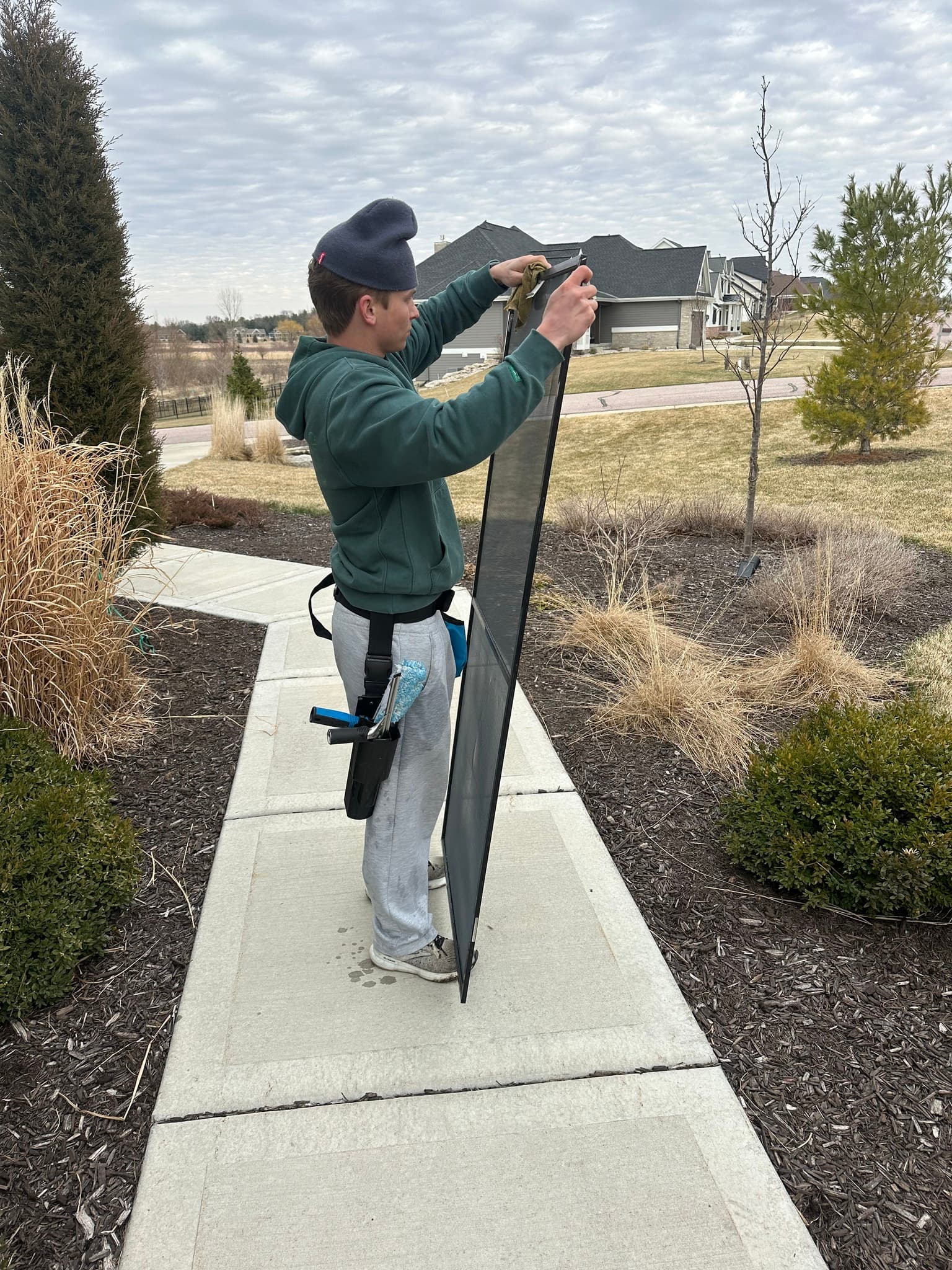 Pure View cleaning a window screen on a sunny day in Sun Prairie